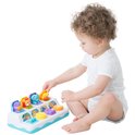 Baby met krullend haar speelt met het pop-up jungle pals speelgoed, drukt op een gele knop.
