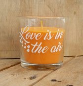 Oranje geur kaars (perziken) met de tekst "Love is in the air