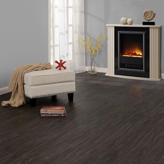Een woonkamer met een donkerbruine PVC vloer, een open haard, een voetenbank en een raam.