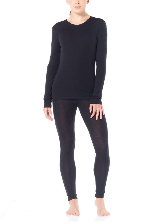 Model draagt een zwart thermoshirt met lange mouwen en zwarte legging.
