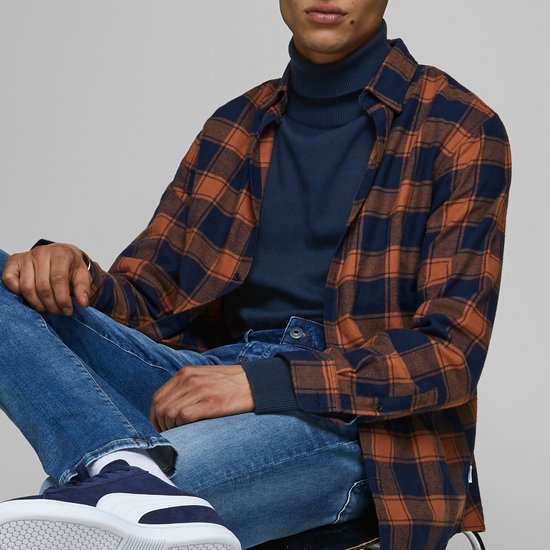 Man met geruite blouse over donkerblauwe coltrui