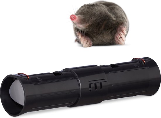 Een mol met roze neus kijkt omhoog naast de zwarte, diervriendelijke mollenklem op een witte achtergrond.