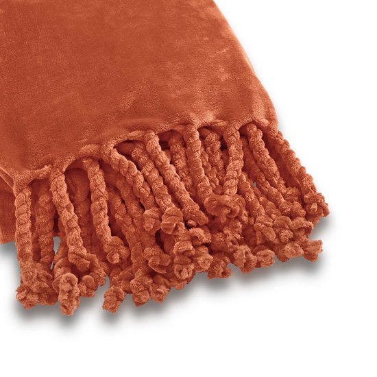 Detail van een oranje plaid met gedraaide flosjes.