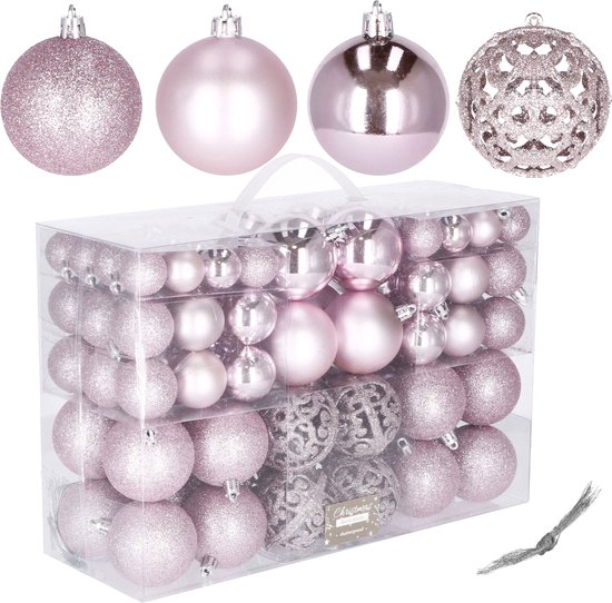 Een transparante doos met roze kerstballen en vier losse ballen op de voorgrond.