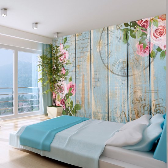 Mur en bois bleu clair avec roses roses et un motif d'horloge.