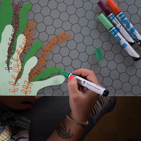 Hand met groene stift tekent planten op grijs rasteroppervlak. Vier stiften liggen klaar.