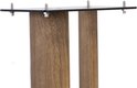 Detail van de bovenkant van een houten luidsprekerstandaard met een zwarte metalen plaat en vier scherpe pinnen.