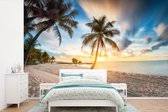 Behang - Fotobehang Zonsondergang - Strand - Palmboom - Breedte 330 cm x hoogte 220 cm