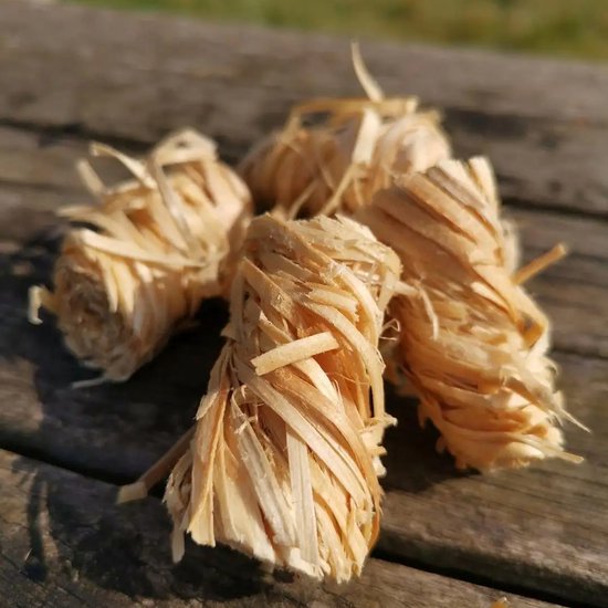 Vijf aanmaakwokkel van houtwol op een houten tafel.
