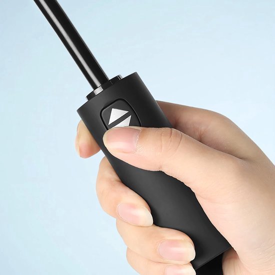Hand die de zwarte, automatische knop van een paraplu indrukt.