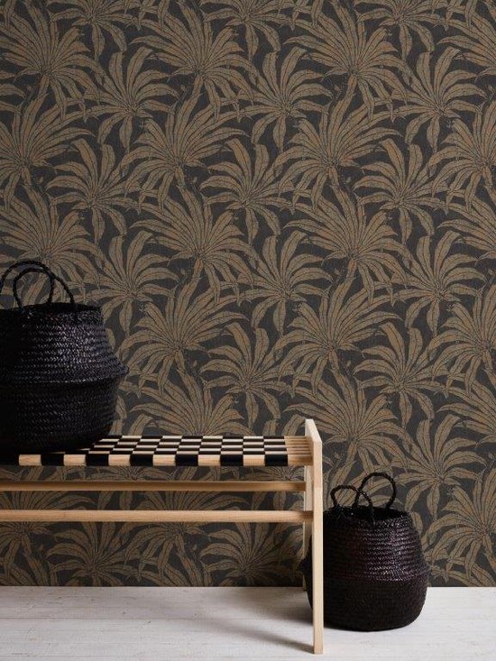 Een houten bankje met twee zwarte manden voor een muur met donker behang en gouden junglebladeren.