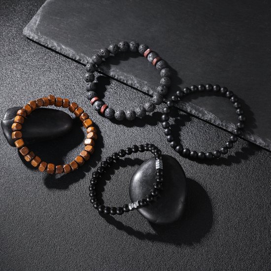 Vier herenarmbanden met zwarte kralen, lavasteen en houten kralen op een donkere achtergrond.