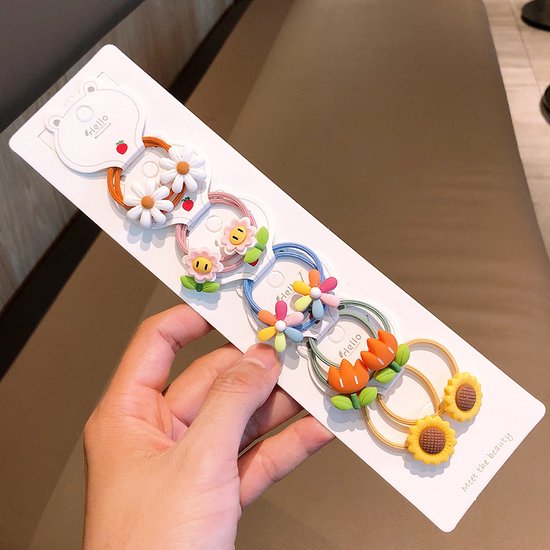 Een set van vijf kinder haarelastiekjes met bloemvormige bedeltjes, inclusief margrieten, zonnebloemen en tulpen in diverse kleuren.