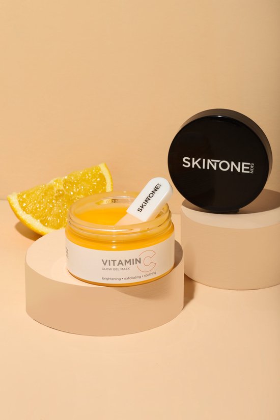 Gouden gelmasker in een potje met deksel, op een display met sinaasappelschijfjes.