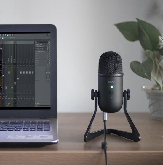 Zwarte Fifine K678 microfoon op een standaard naast een laptop met muzieksoftware.