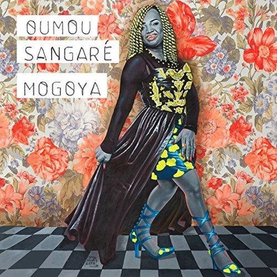 Albumhoes met Oumou Sangaré op een bloemenbehang, met gele en blauwe kleding en hoge hakken.