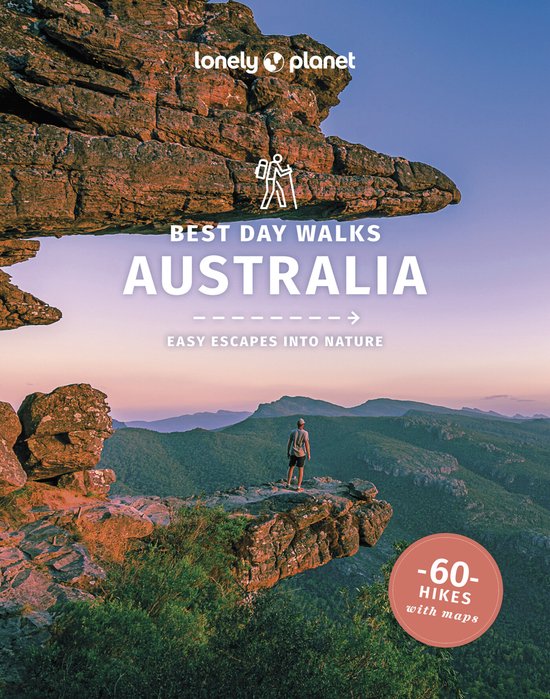Boek "Lonely Planet Best Day Walks Australia" met een wandelaar op een rots met uitzicht op een berglandschap bij zonsondergang.