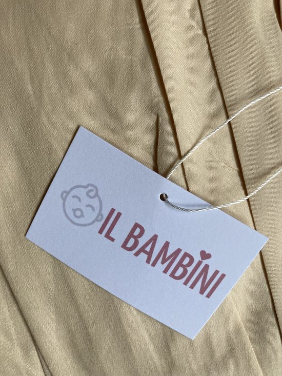 Witte kaart met logo 'IL BAMBINI' en een slapend gezichtje, aan een crèmekleurige stof.
