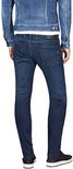 Man met donkerblauwe jeans en spijkerjasje, gezien vanaf de achterkant.