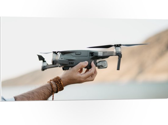 PVC Schuimplaat- Drone in Handen van Mensen - 100x50 cm Foto op PVC Schuimplaat