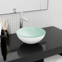 Lavabo blanc avec un bord supérieur en verre vert clair, sur un plan de travail noir.