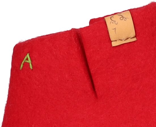 Rode wollen slof met groene "A" en een bruin label met cijfers.