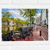 Muursticker - Rij Fiets Geparkeerd langs de Gracht in Amsterdam - 40x30 cm Foto op Muursticker