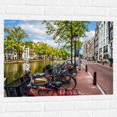 Muursticker - Rij Fiets Geparkeerd langs de Gracht in Amsterdam - 80x60 cm Foto op Muursticker