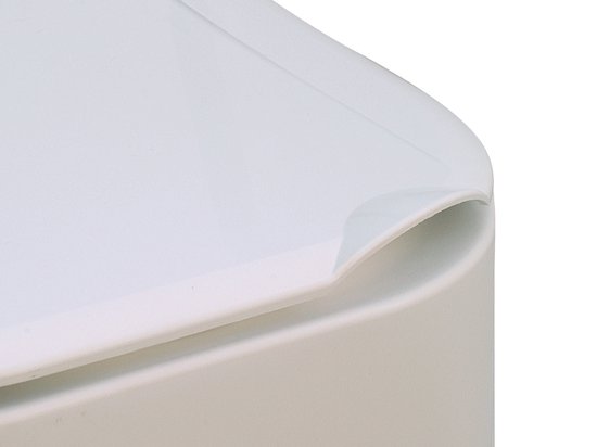 Detail van de gladde, witte dekselrand van een toiletverhoger.