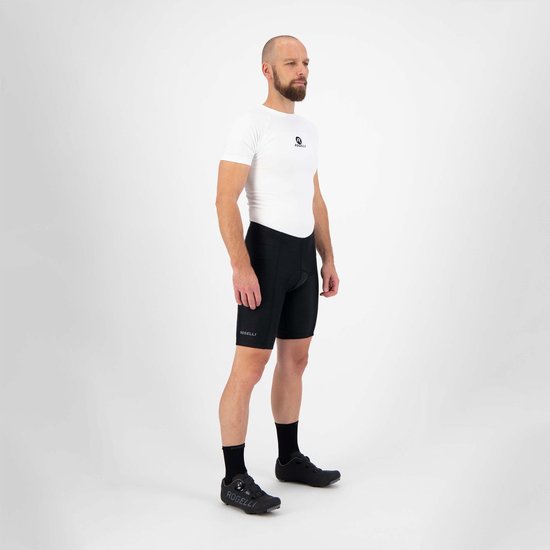 Man van de zijkant gezien, draagt een witte fietsjersey en zwarte fietsbroek met Rogelli logo.