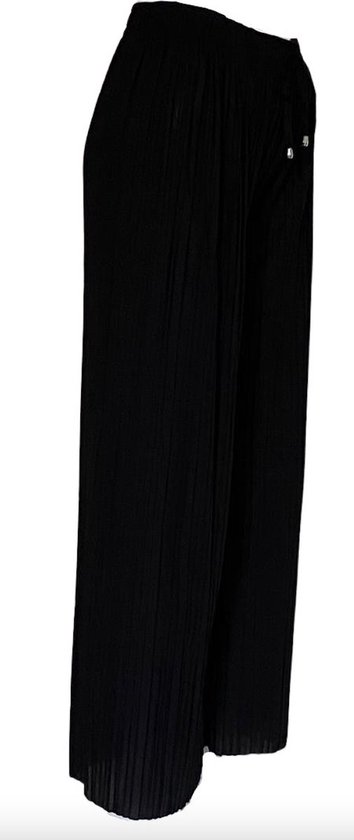 Zijkant van een zwarte wijde broek met plooien en trekkoord
