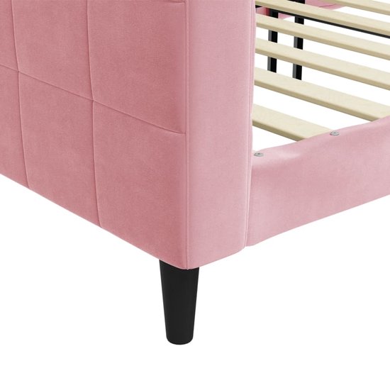 Detail van de hoek van een lichtroze slaapbank met gecapitonneerd zitvlak en zwarte poot.