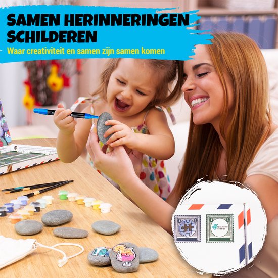 Vrouw en kind schilderen samen op stenen, met verf en penselen op tafel.