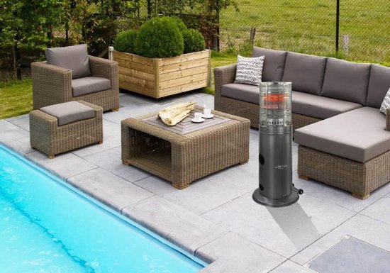 Een staande terrasverwarmer op een betegeld terras bij een zwembad, met een loungeset en een salontafel.