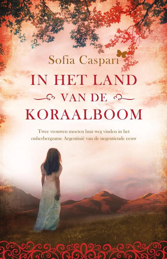 Boekcover: In het land van de koraalboom. Een vrouw in wit jurkje kijkt uit over glooiend landschap met bergen.
