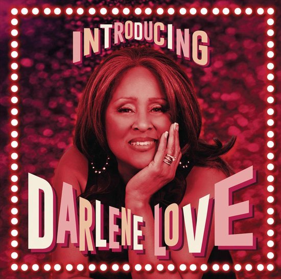 Introducing Darlene Love, een portret van de zangeres met donker haar en een glimlach, omringd door lichtjes.