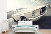 Behang - Fotobehang Een witte Ford Mustang op een parkeerplaats - Breedte 600 cm x hoogte 400 cm