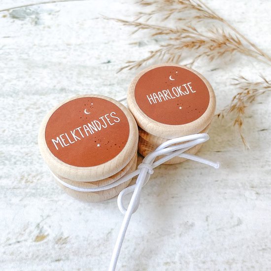 Twee houten doosjes met bruine stickers met maan en sterren. 'MELKTANDJES' en 'HAARLOKJE'. Bijeengehouden door wit touwtje.