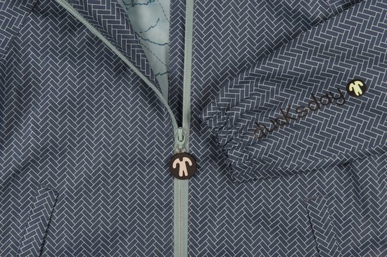 Detail van een blauw jack met visgraatpatroon, ritssluiting met een eend-vormige hanger.
