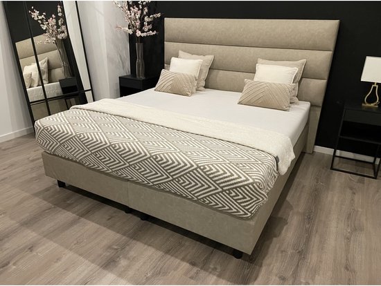 Beige boxspring 180x200cm met geometrisch patroon deken in beige en grijs. Hoge, gestoffeerde hoofdbord.
