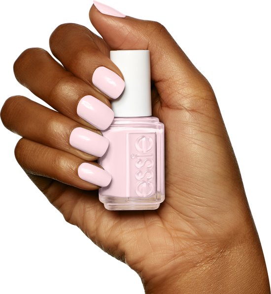 Donkere hand met een lichte roze Essie nagellak.