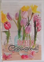 Hartelijk gefeliciteerd! Een kleurrijke wenskaart met mooie tulpen in een vaas. Een leuke kaart om zo te geven of om bij een cadeau te voegen. Een dubbele wenskaart inclusief envelop en in folie verpakt.