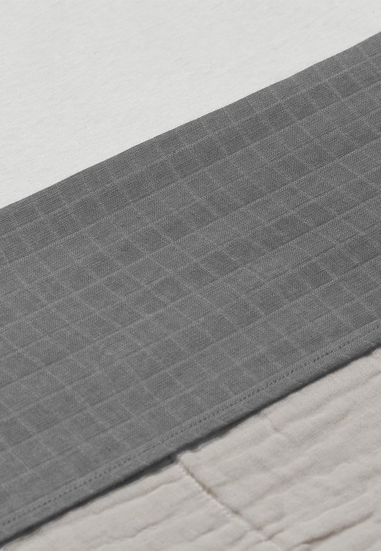 Baby ledikantlaken in wit, grijs en beige met een gekreukelde textuur. De grijze band is diagonaal.