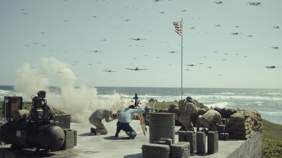 Gevechtsscène met vliegtuigen, artillerie en soldaten op een rotsachtige kust.