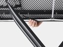 Hand en vinger bevestigen het zwarte frame aan de onderkant van de strijkplank.