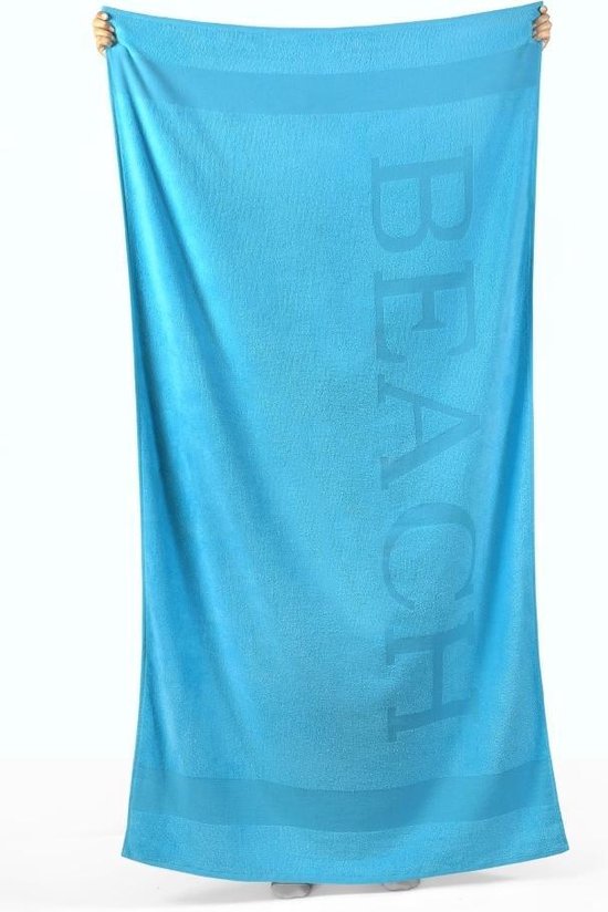 Blauw strandlaken met "BEACH" in reliëf, vastgehouden door twee handen.