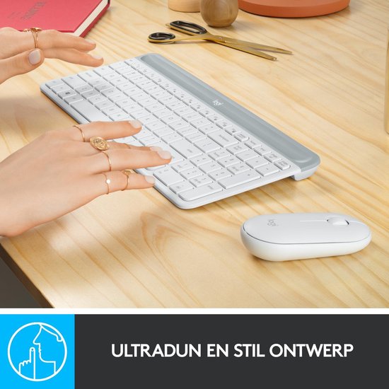 Handen typen op een wit Logitech toetsenbord, met muis ernaast.