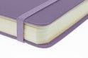 Dichtbijopname van een paars schetsboek met een elastische sluiting.