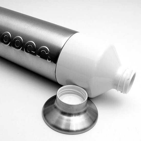 Dopper en acier inoxydable posé, avec un goulot blanc et un bouchon argenté à côté.