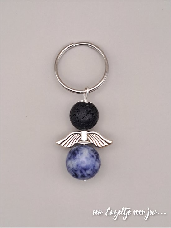 Sleutelhanger met een engel van zwarte lavasteen en blauw gespikkelde dalmatïër jaspis, met zilverkleurige vleugels.